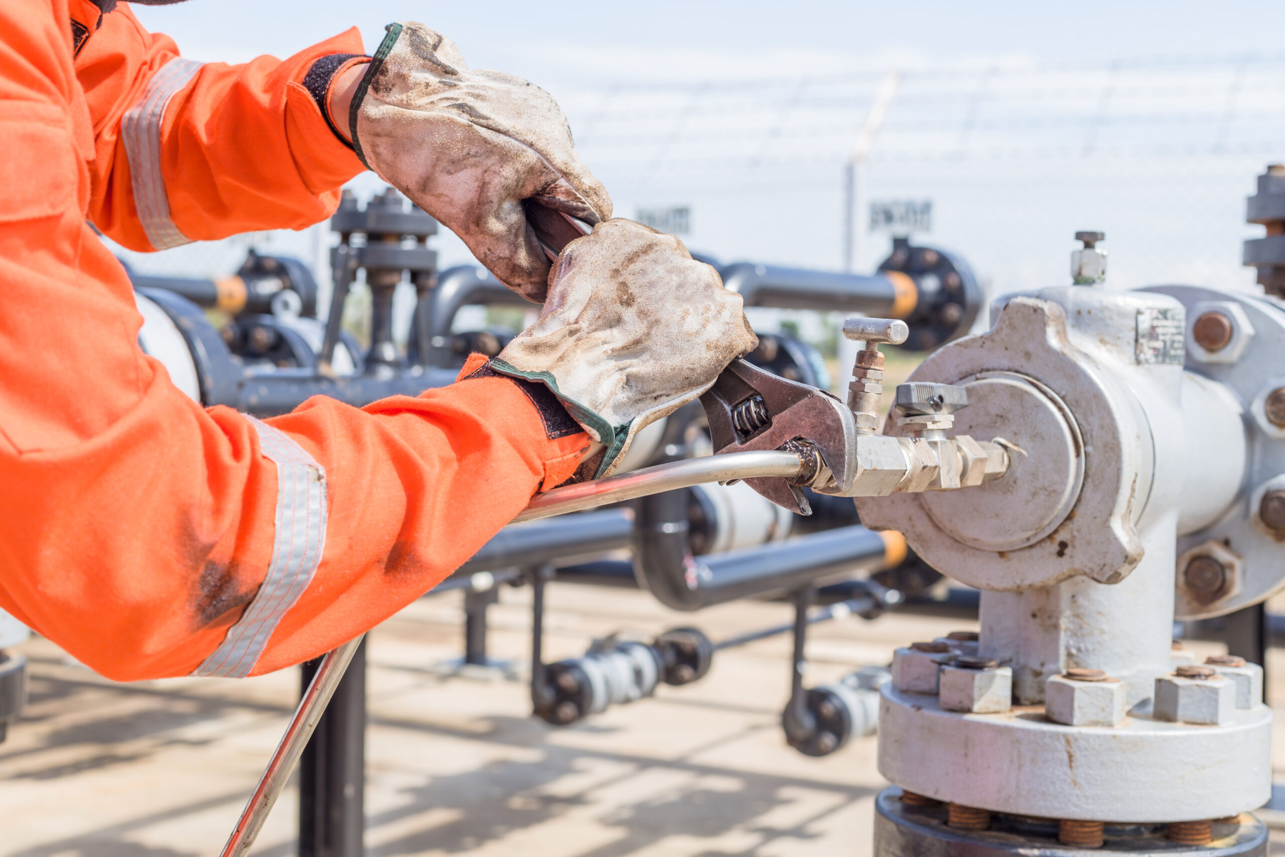 Close-up image of human hand fixing and stop leak stainless tube by wrench in oil and gas process.
